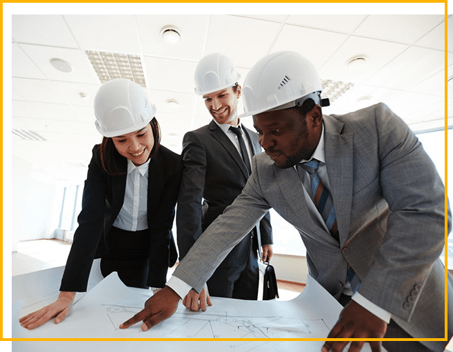 Three people in hard hats looking at a plan.